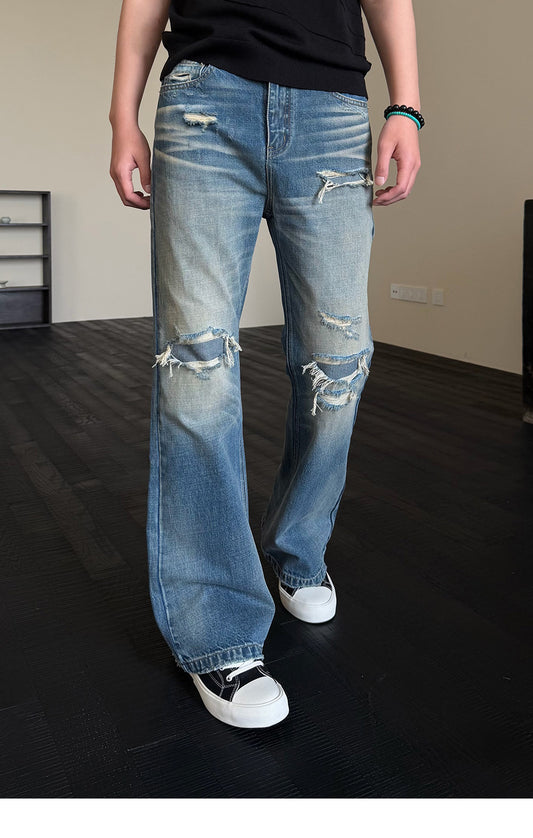 Micro-flared jeans with hole patches and distressed detailing